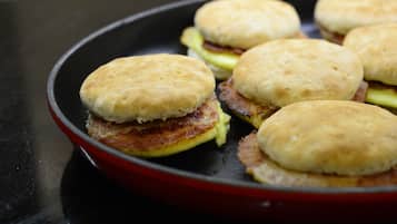 A skillet with breakfast sandwiches.