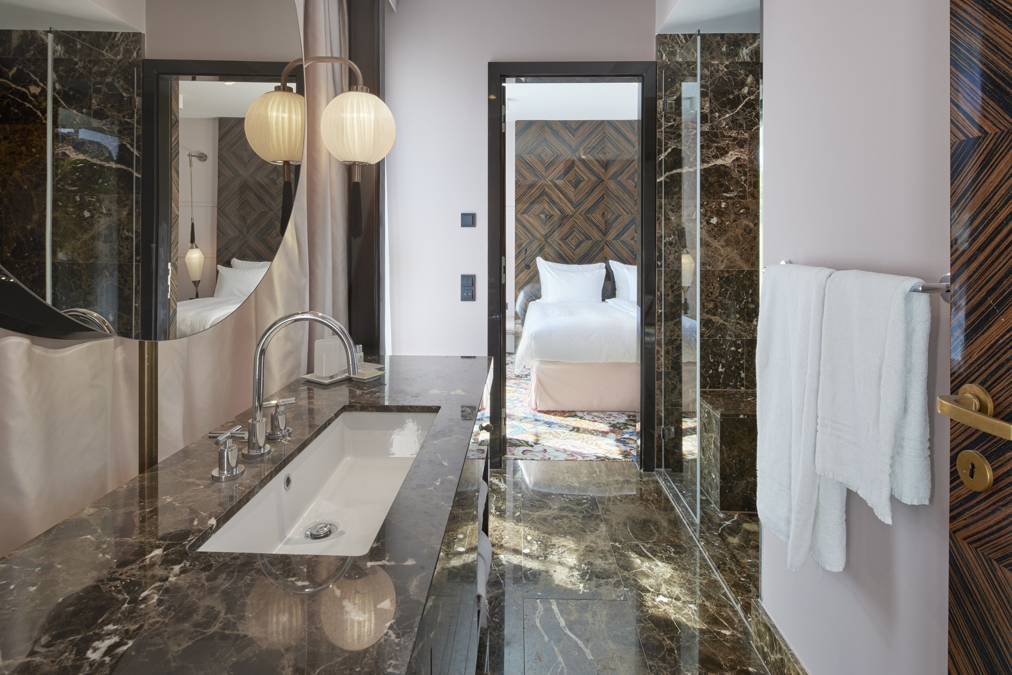 A modern bathroom with a large mirror, a sink, and a shower area.
