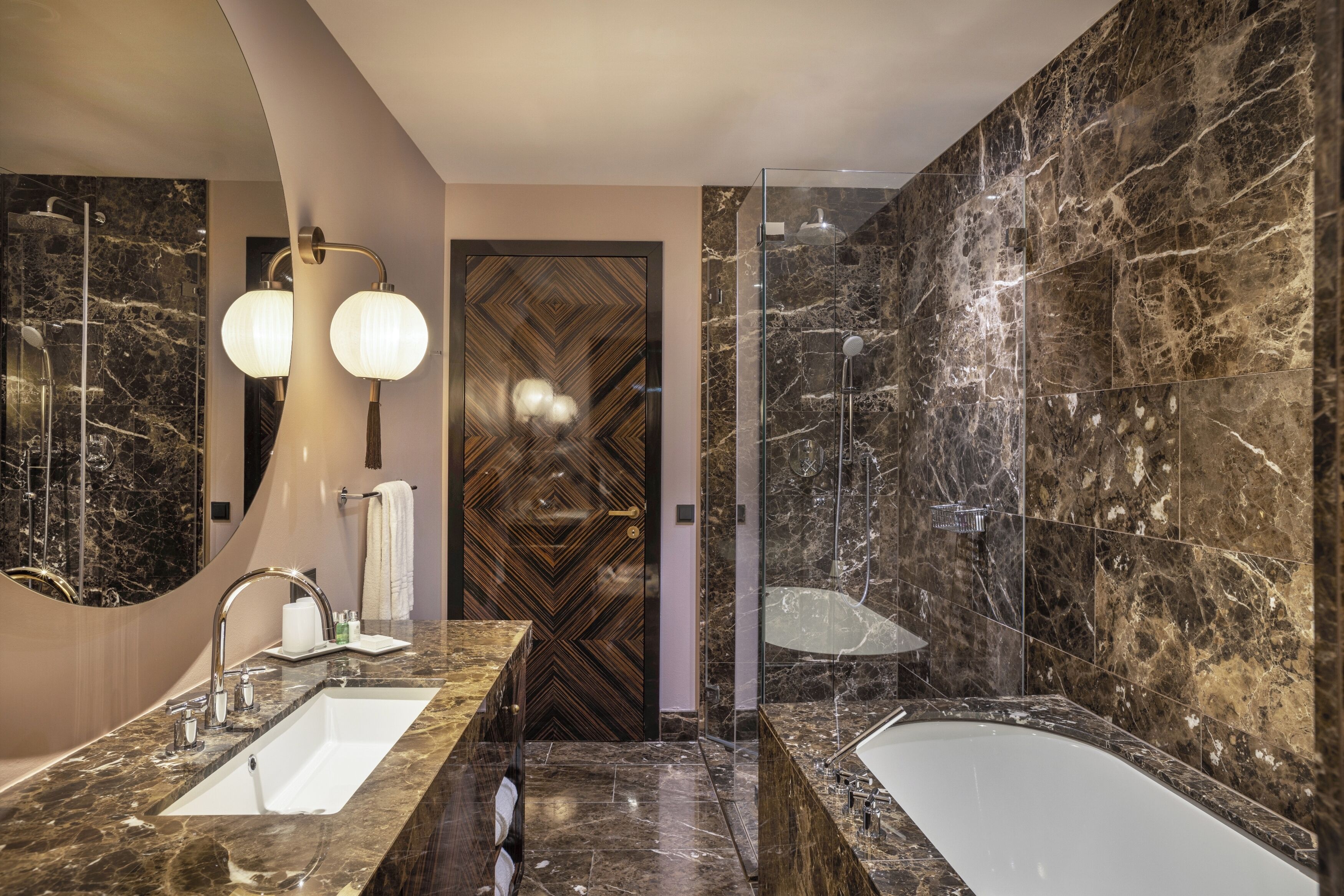 A modern bathroom with a large mirror, two sinks, a bathtub, and a shower area.