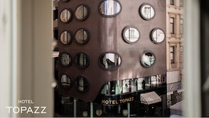 A building with multiple circular windows and a sign reading "HOTEL TOPAZZ".