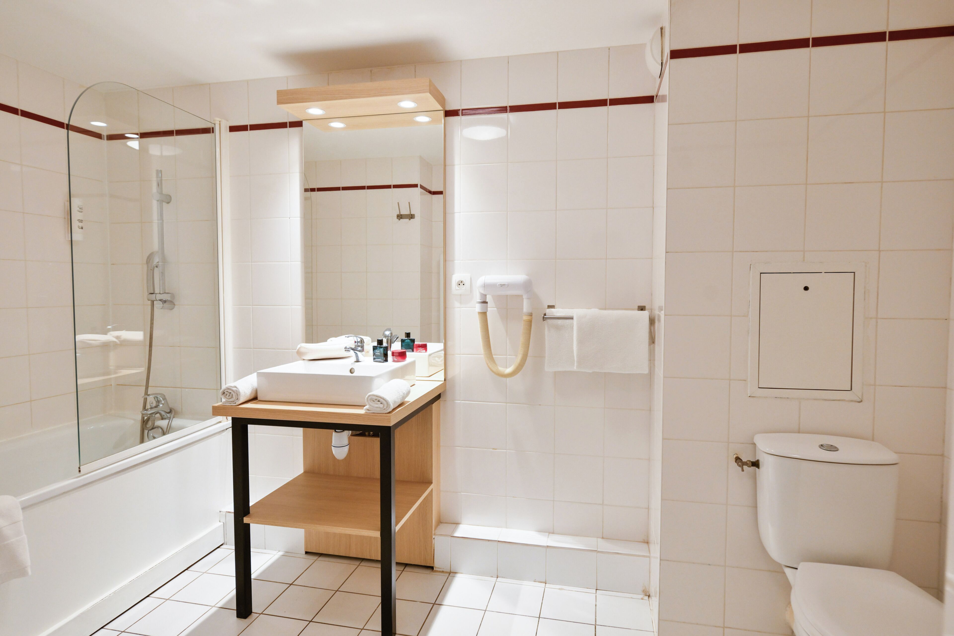 Une salle de bain moderne avec une douche à parois de verre, un meuble-lavabo en bois et des toilettes.