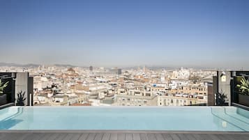 Una piscina al aire libre, sillones reclinables de piscina