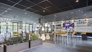 A modern hotel lobby with glass walls, seating areas, and a reception desk. - Hotel Andante Drassanes (Barcelona)