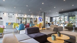 A modern lobby with comfortable seating, a vending machine, and a large glass wall offering a view of the outdoors. - Hotel Andante Drassanes (Barcelona)