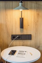 Una mesa redonda blanca con un teléfono inteligente, un cartel con la palabra 