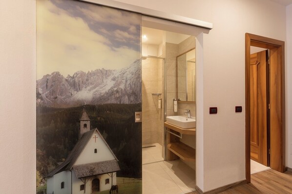 A bathroom with a shower, a sink, and a mirror. - Resort Dolce Casa Family &SPA (Moena)
