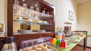 A buffet setup with various food items, a coffee station, and a beverage dispenser. - Hotel Trastevere (Rome)