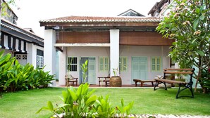 A traditional building with a tiled roof, a covered porch, and a garden area with benches and a large planter. - 23 LoveLane Penang (George Town)