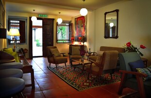 A cozy living room with a sofa, armchairs, a coffee table, and a patterned rug.