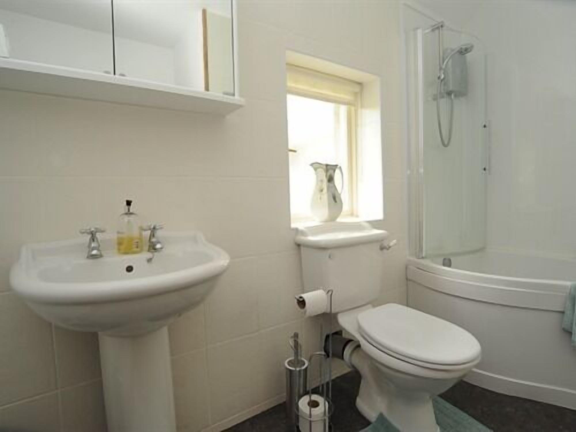 Un baño con lavabo, inodoro y ducha.