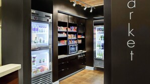 A modern interior with refrigerated display cases and shelves stocked with various products. - Courtyard Boone (Boone)
