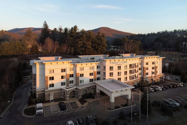 A Courtyard by Marriott hotel with a central courtyard, multiple floors, and a parking lot.