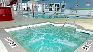 An indoor swimming pool with clear water, marked depth levels, and a red water feature. - Best Western Plus Rose Country Hotel (Camrose)