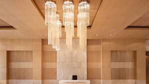 A modern lobby with a reception desk, two chairs, and a patterned floor. - Radisson Blu Hotel Amritsar (Amritsar)