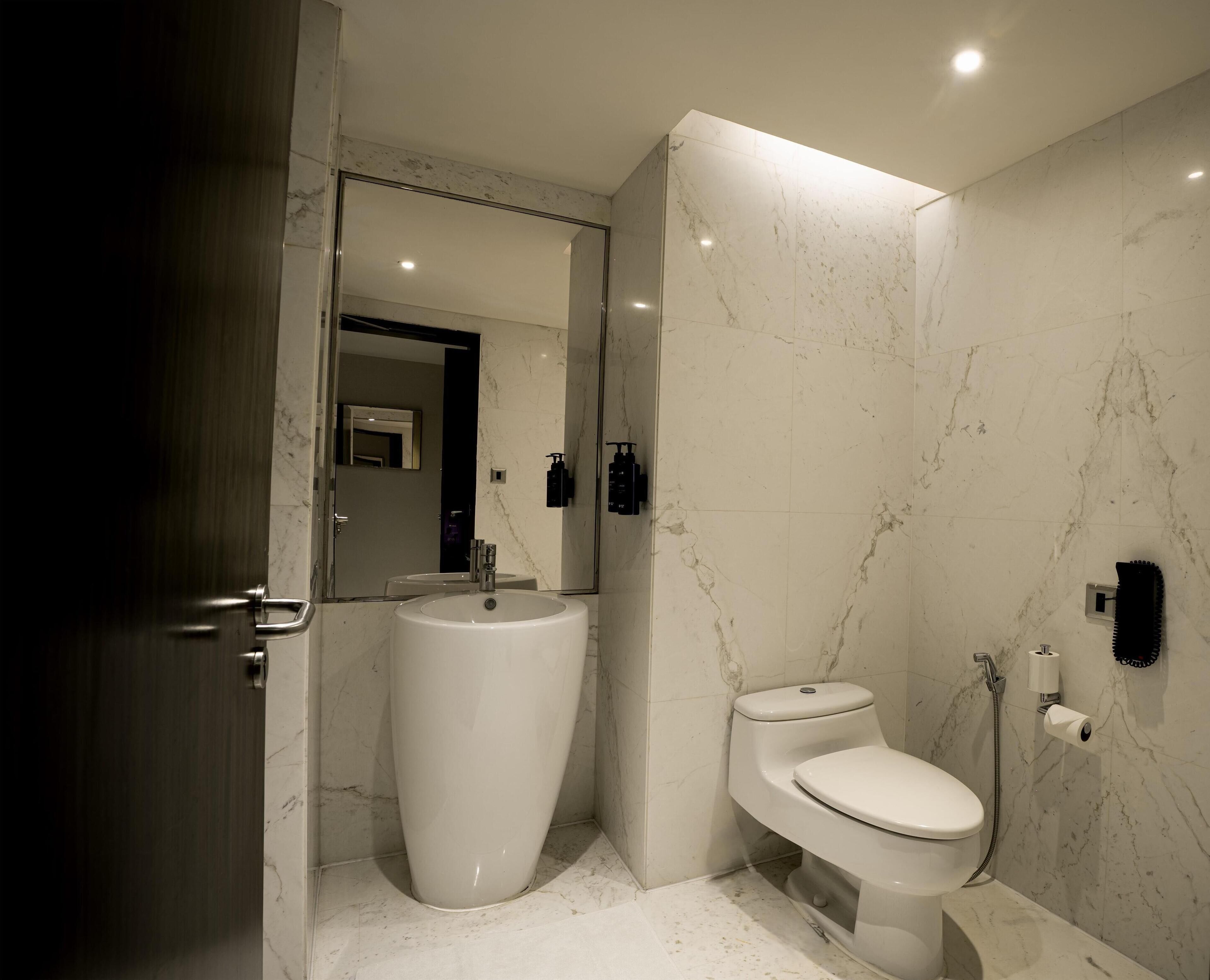 A modern bathroom with a large sink, toilet, and shower.