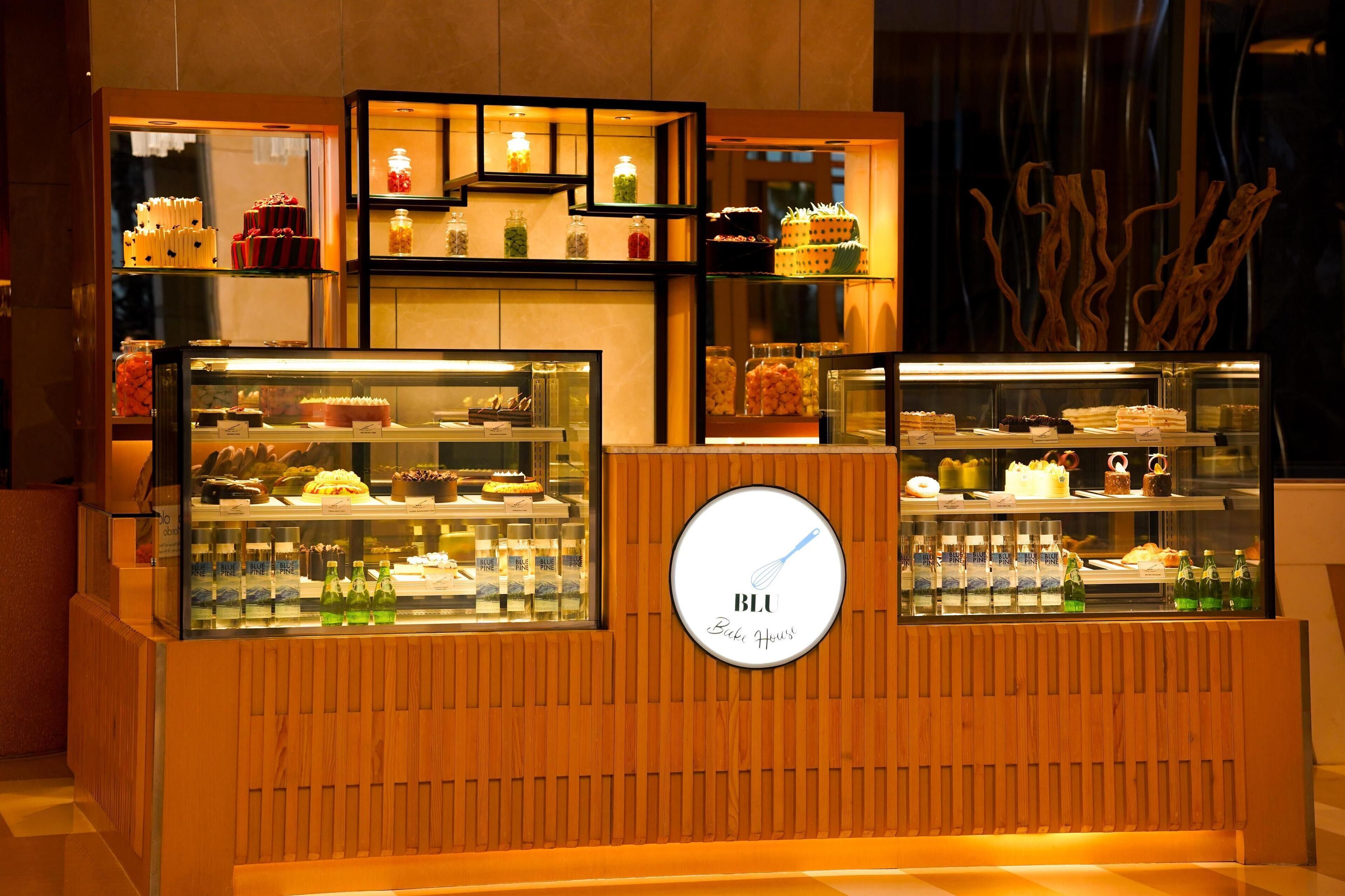 A bakery display with various baked goods and a sign that reads "BLU Bakery House."