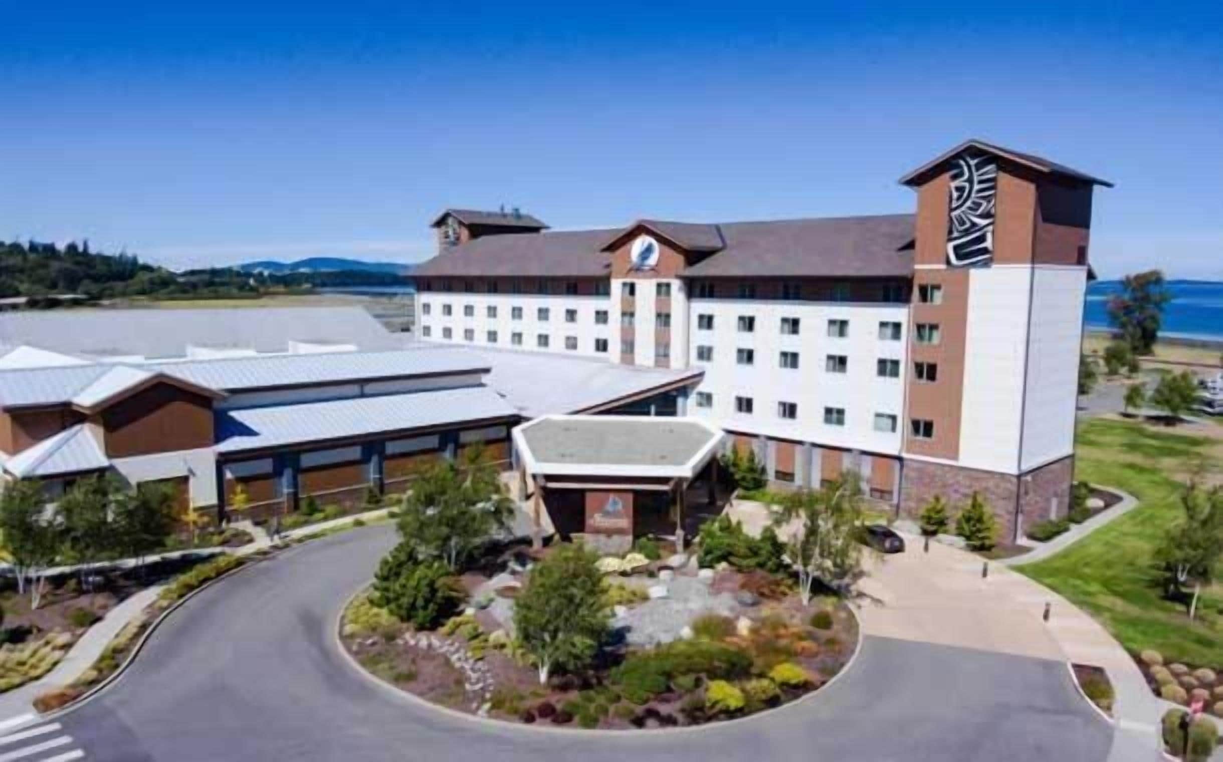 A hotel with a central courtyard, multiple buildings, and a view of the water.
