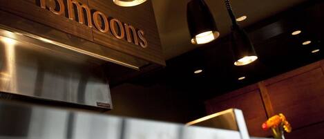 A restaurant interior with a sign reading "13moons" and pendant lighting.