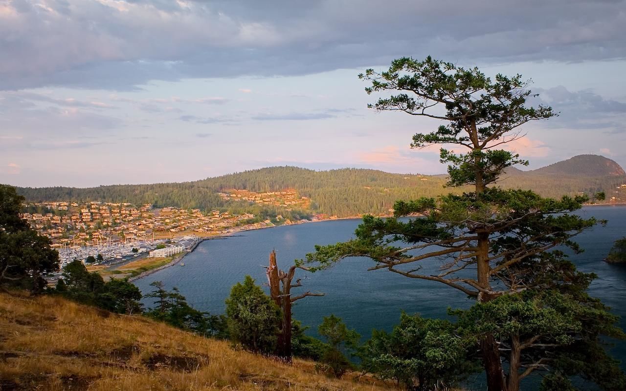 A coastal town with a view of the sea and mountains in the background.