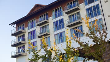 Un edificio de varios pisos con balcones y grandes ventanales.