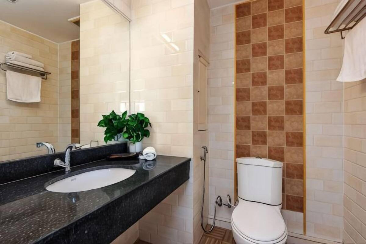 A bathroom with a double sink, a toilet, and a shower.
