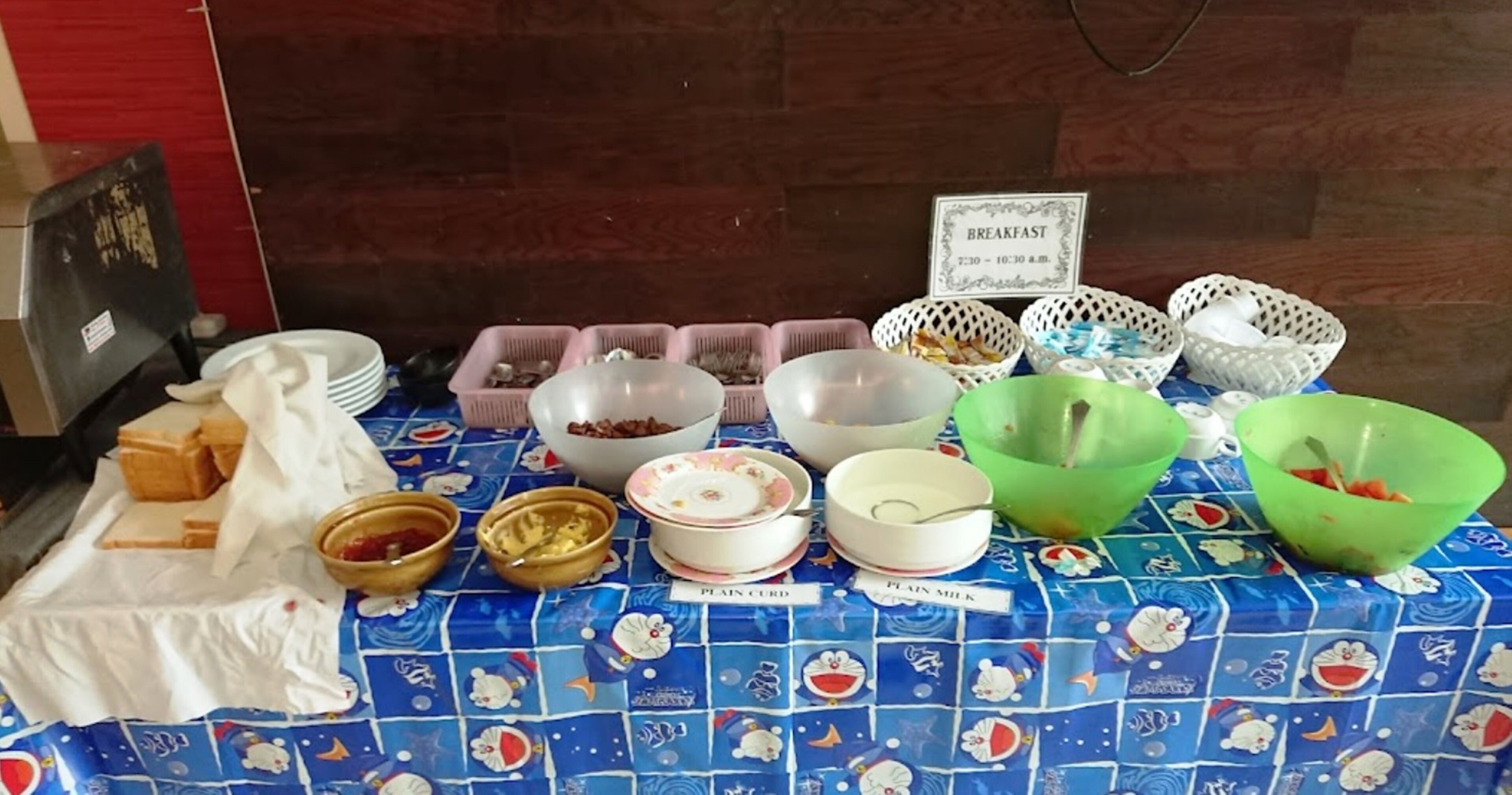 A breakfast buffet table with various food items and labeled containers.