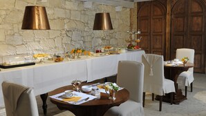 Un comedor con una larga mesa dispuesta para una comida, rodeada de sillas.