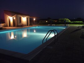 Una piscina al aire libre de temporada, sombrillas