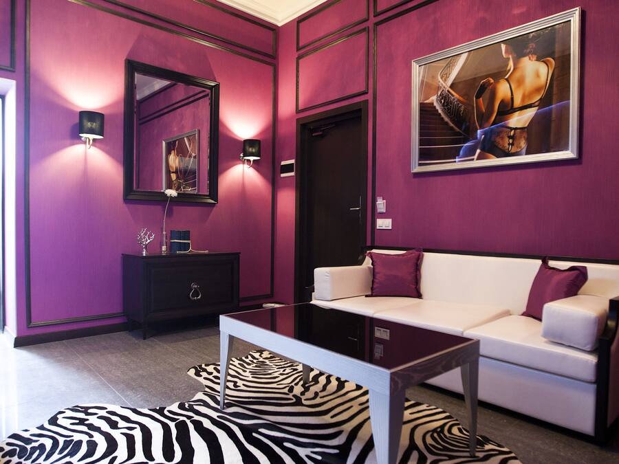 A modern living room with a zebra-patterned rug, a white sofa, and a black cabinet.