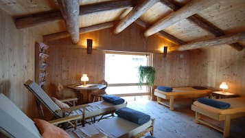 Una cabaña de madera con cuatro camas individuales, una mesita y un banco.