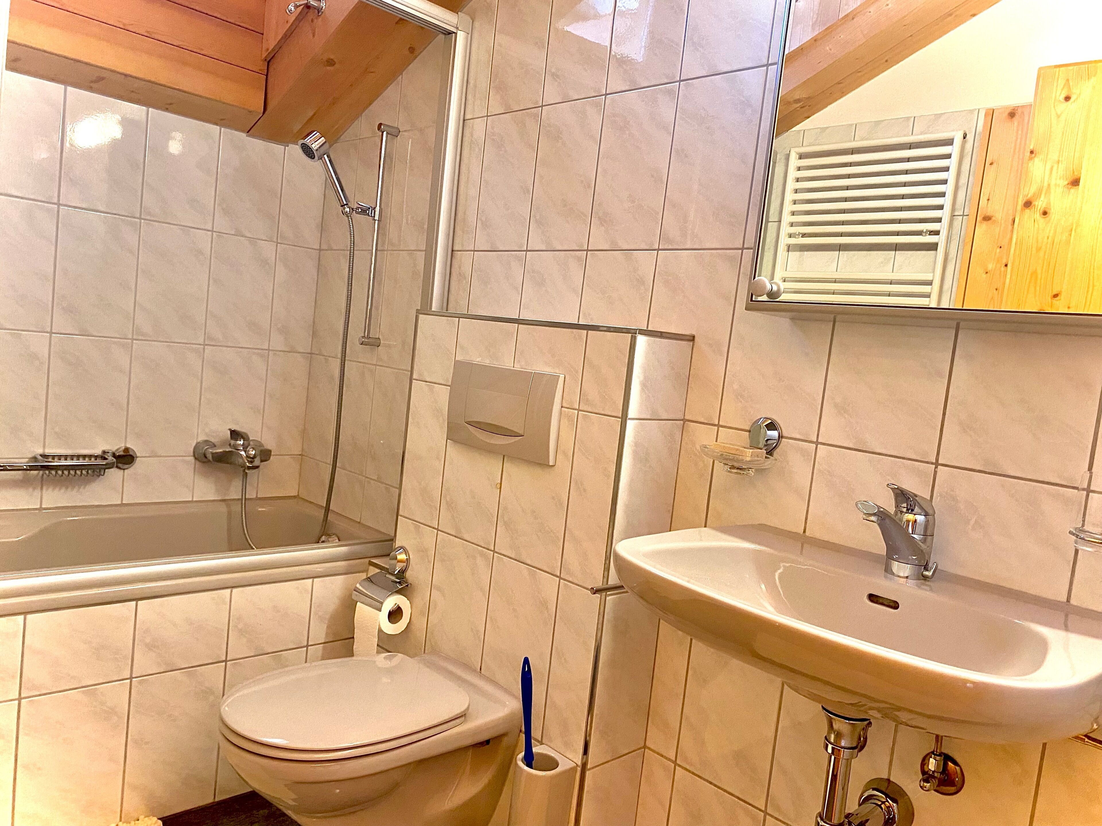 A bathroom with a toilet, sink, and shower.