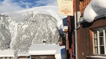 A sign for the DUCAN Hotel with a view of snow-covered mountains in the background.