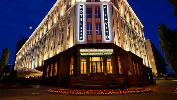 A hotel with a classic architectural style, featuring a prominent marquee sign, multiple windows, and a well-lit entrance. - ALFAVITO Kyiv Hotel (Kyiv)