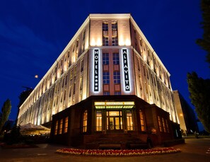 A hotel with a classic architectural style, featuring a prominent marquee sign, multiple windows, and a well-lit entrance. - ALFAVITO Kyiv Hotel (Kyiv)