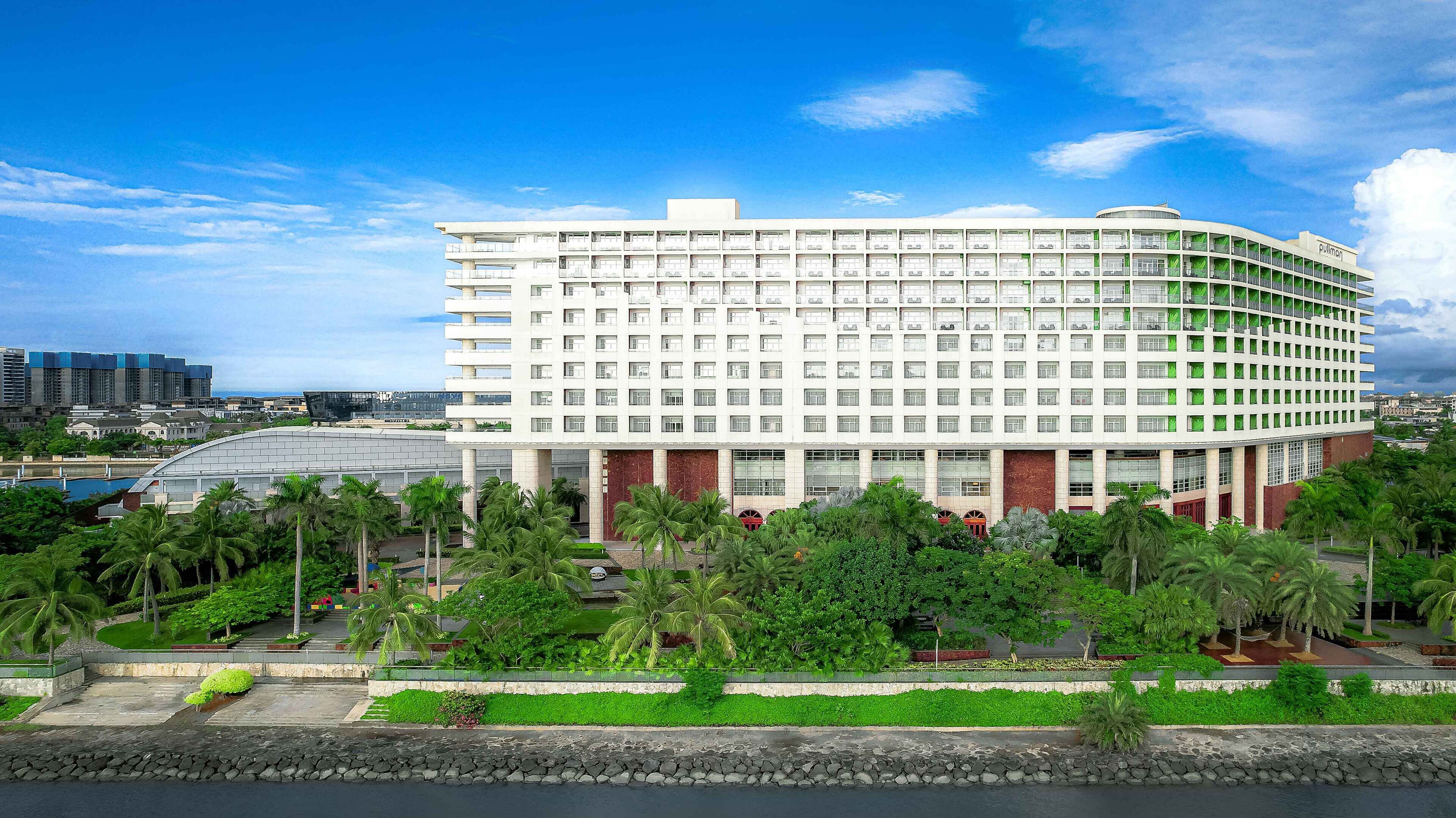 A large, multi-story hotel with a modern design, featuring a curved facade and numerous windows.