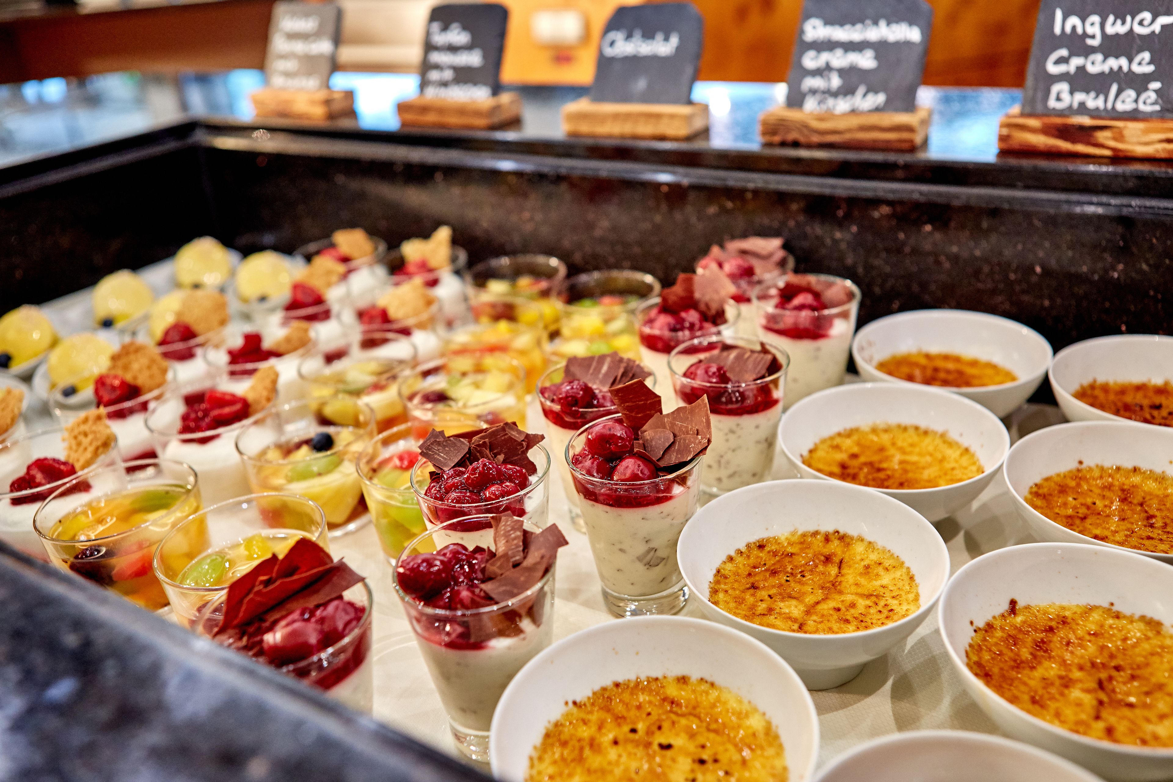 Une présentation de desserts comprenant différents types de douceurs, servis dans des bols et des verres.