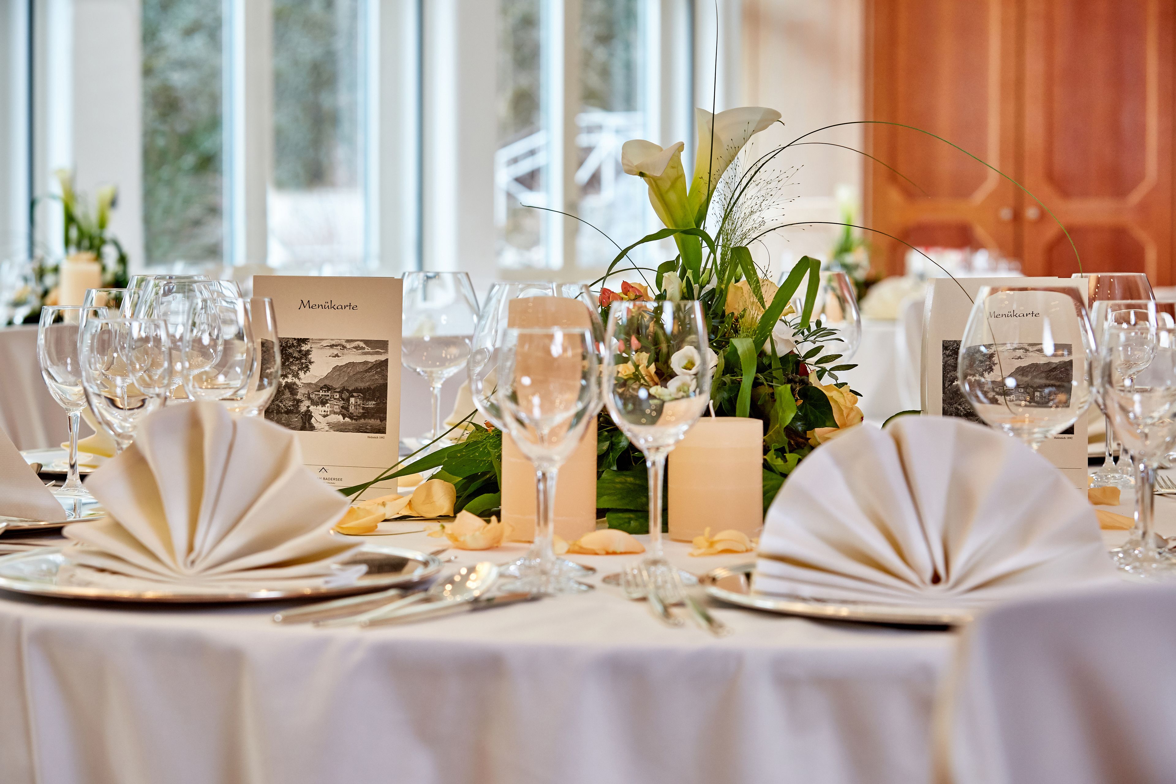 A table set for a formal event with wine glasses, plates, and menus.