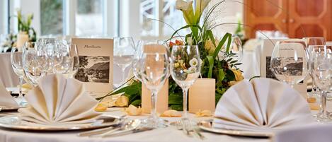 A table set for a formal event with wine glasses, plates, and menus.