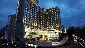 Hotel JW Marriott con diseño moderno, varios pisos y ventanas iluminadas.