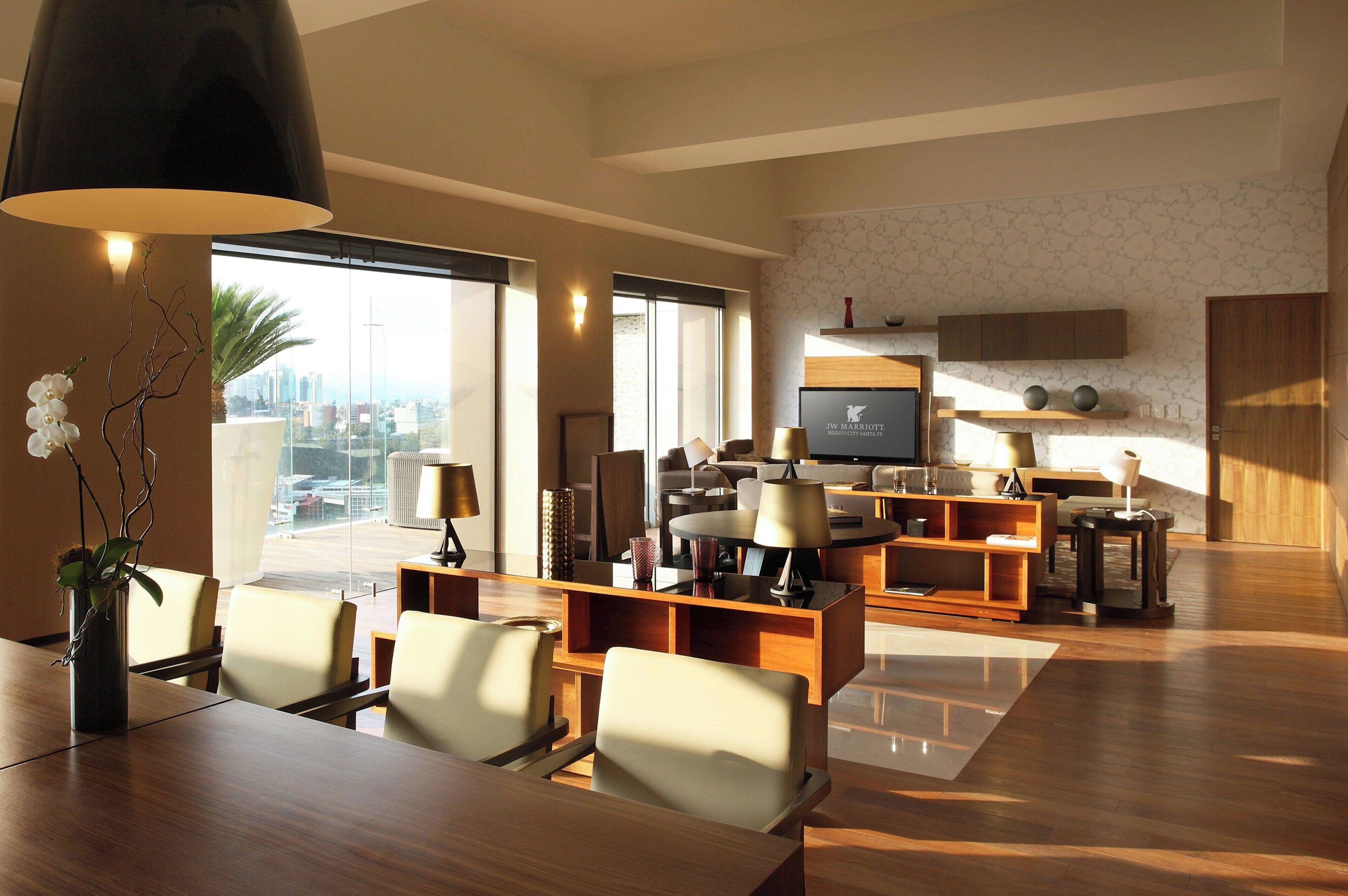 A spacious living area with a large TV, comfortable seating, and a city view.