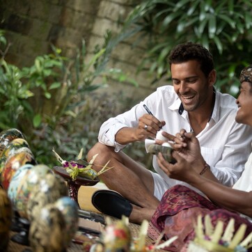 Two people sitting outdoors, engaged in a conversation.