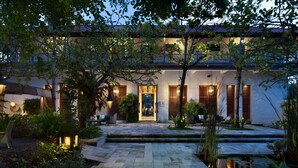 Il s’agit d’un bâtiment traditionnel, doté d’un toit en tuiles, d’une entrée centrale avec une porte et d’un petit jardin agrémenté d’un élément décoratif aquatique.