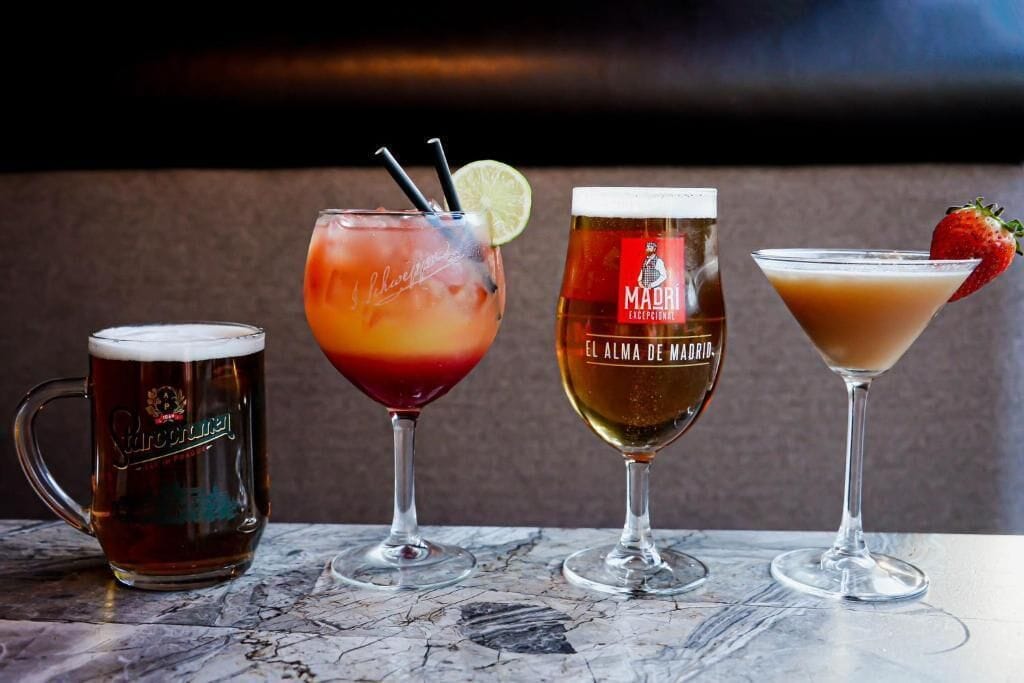 Cuatro tipos diferentes de bebidas sobre una mesa de mármol.