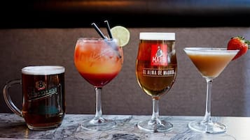 Cuatro tipos diferentes de bebidas sobre una mesa de mármol.