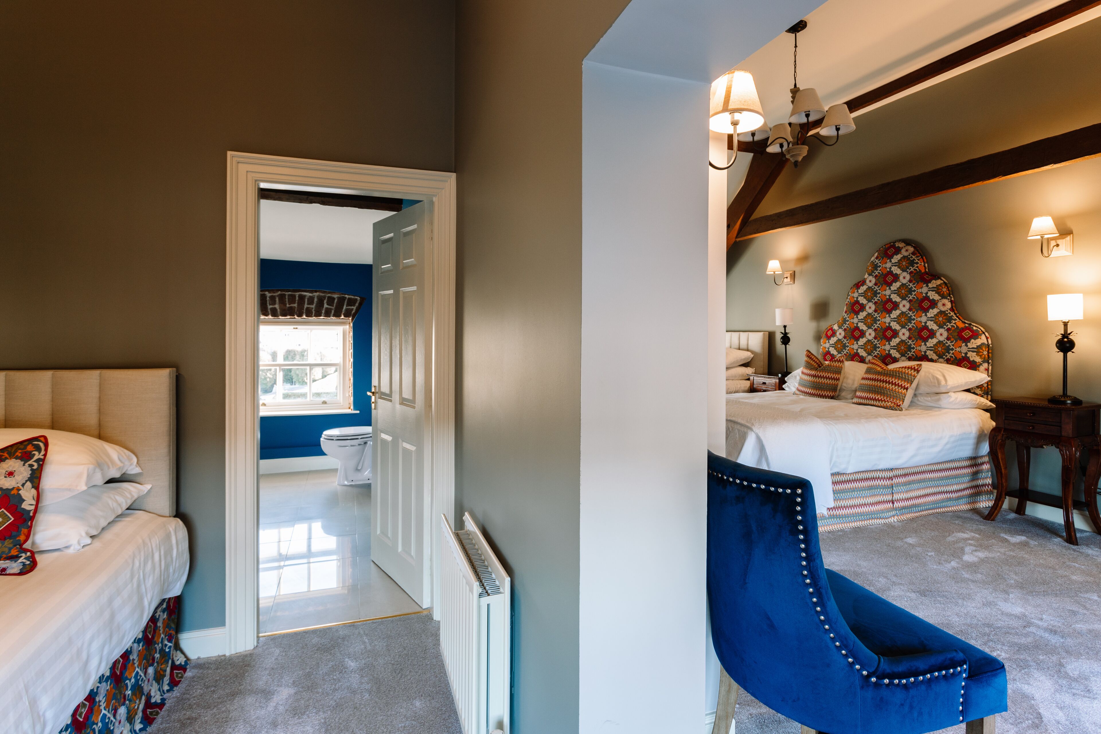 A bedroom with a bed, a chair, a nightstand, and a window.