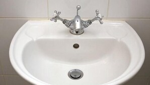 A white pedestal sink with a single faucet and a drain. - Tooting Place Apartments (Mitcham)