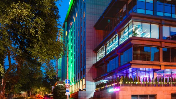 A Holiday Inn hotel with a modern design, featuring a prominent sign and a glass facade.