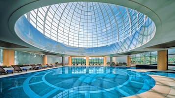 Una piscina techada, una piscina al aire libre de temporada, sombrillas