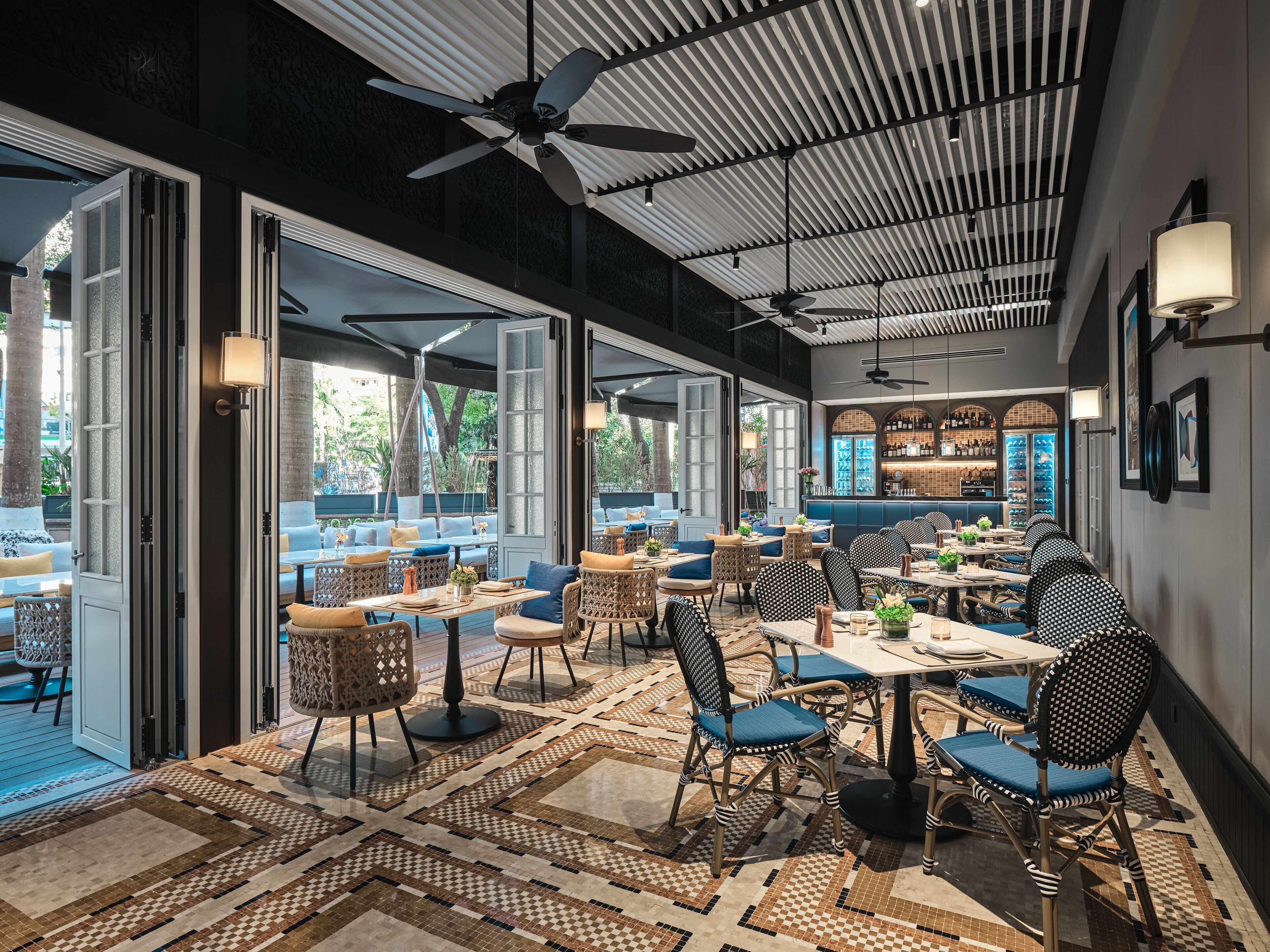A spacious indoor area with open seating, ceiling fans, and a bar area.