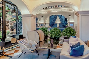 A spacious lobby with a modern lounge area, a seating arrangement, and a view of the bar area.